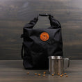 Load image into Gallery viewer, Black dog food travel bag with roll-top closure and orange logo
