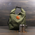 Load image into Gallery viewer, Olive green roll-top dog kibble bag with black chevron strap and orange logo

